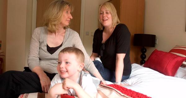 a grandmother, mother and son sat in the bedroom of a property in whitebeck court