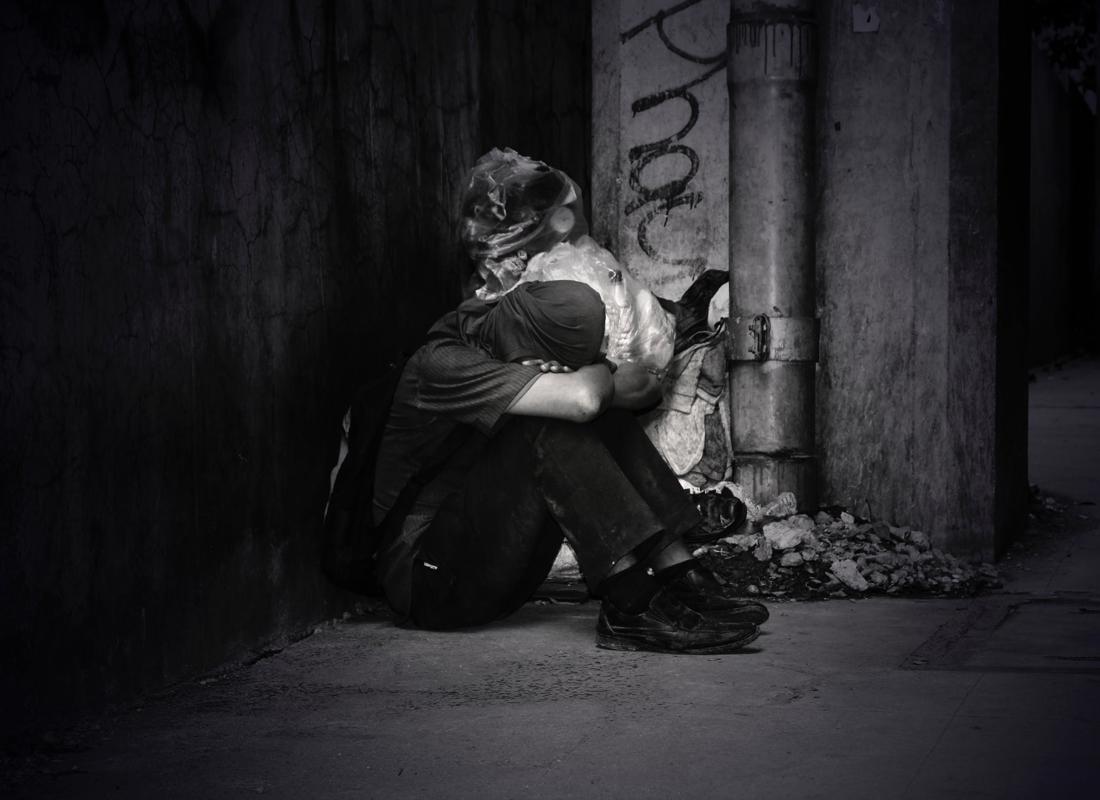 An Image Of A Homeless Man Sitting On The Street