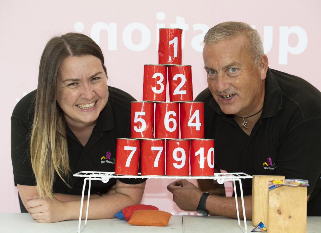 ian and louise posing in front of a coconut shy game