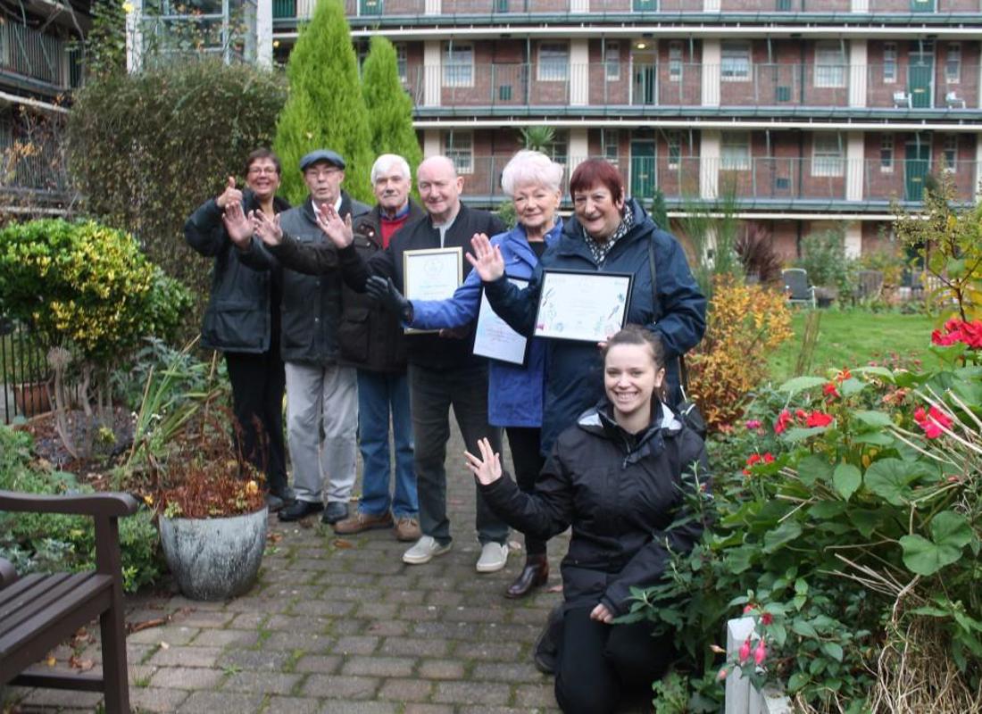 a group of residents smiling at the camera in the garden at victoria square