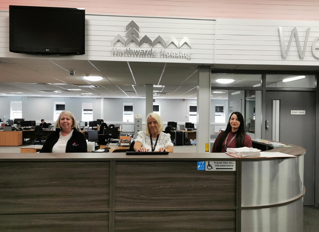 The Customer Service desk at White Moss Road, with three smiling members of staff